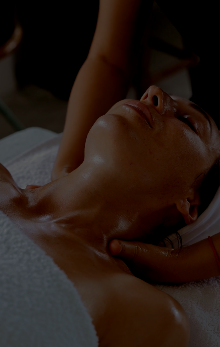 A woman is laying on a bed getting a massage.