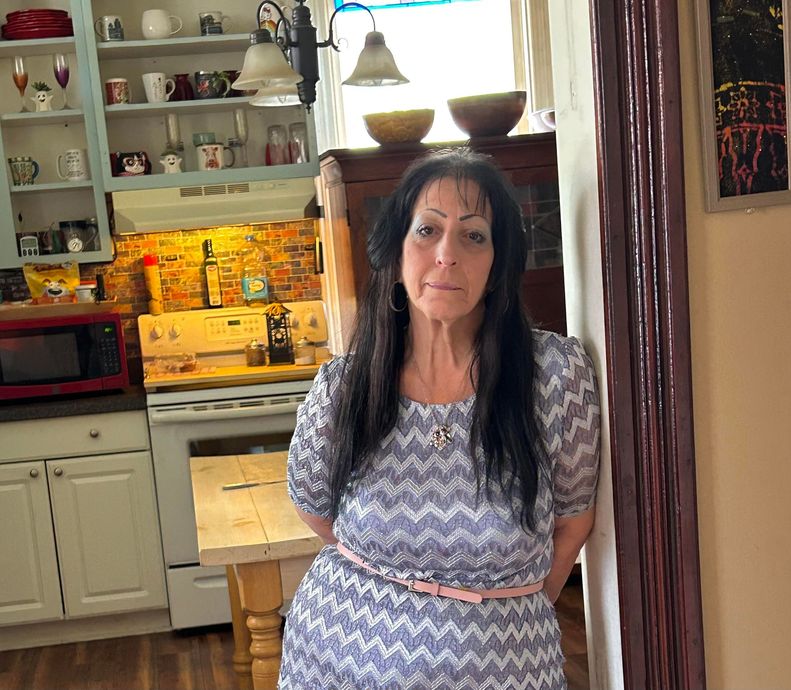 A woman in a chevron dress is standing in a kitchen