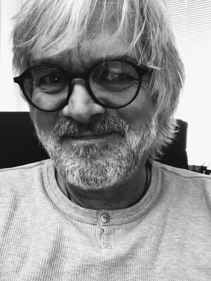 Ein Schwarzweißfoto eines Mannes mit Brille und Bart.