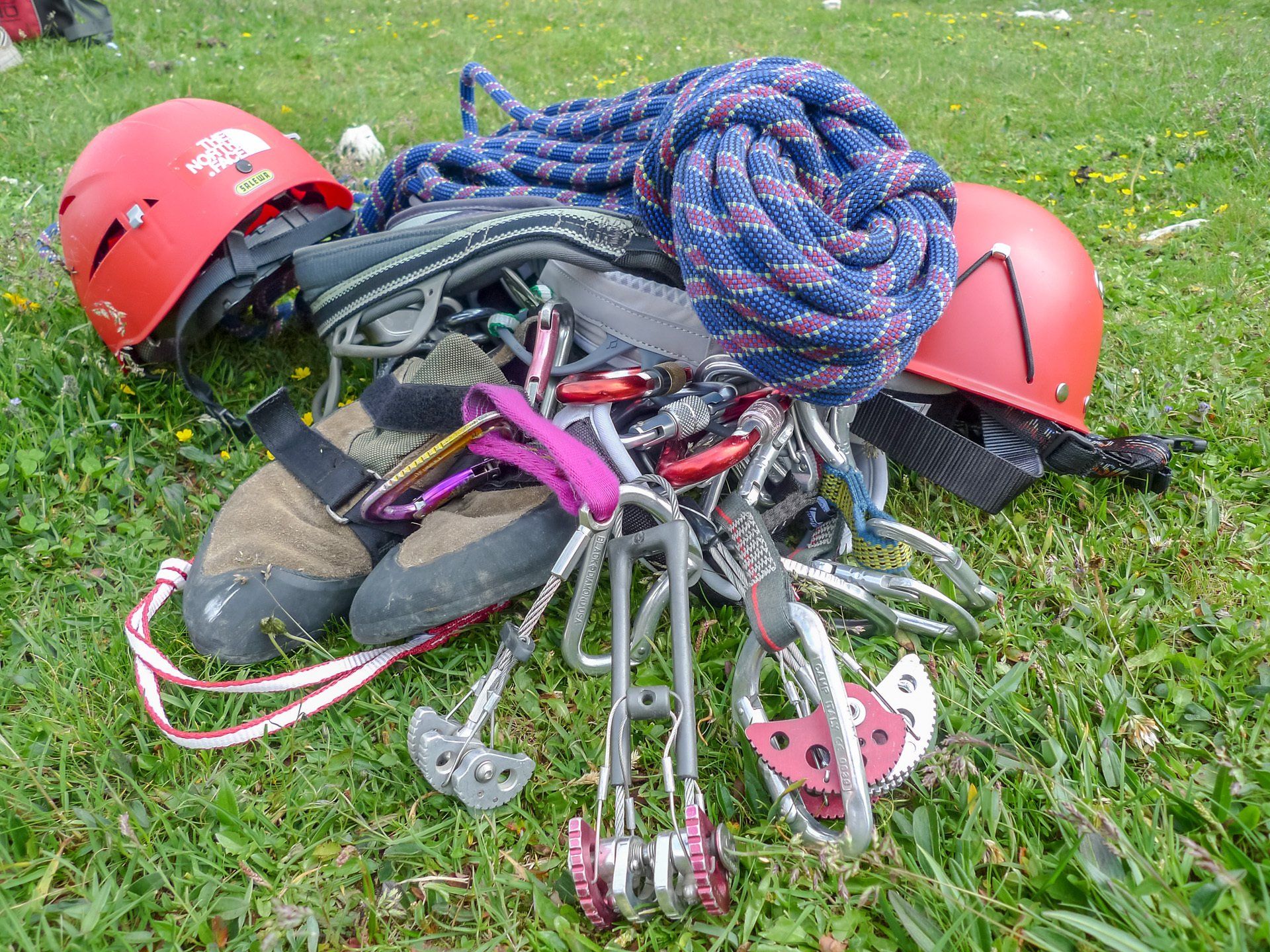 Ein Haufen Kletterausrüstung liegt im Gras.