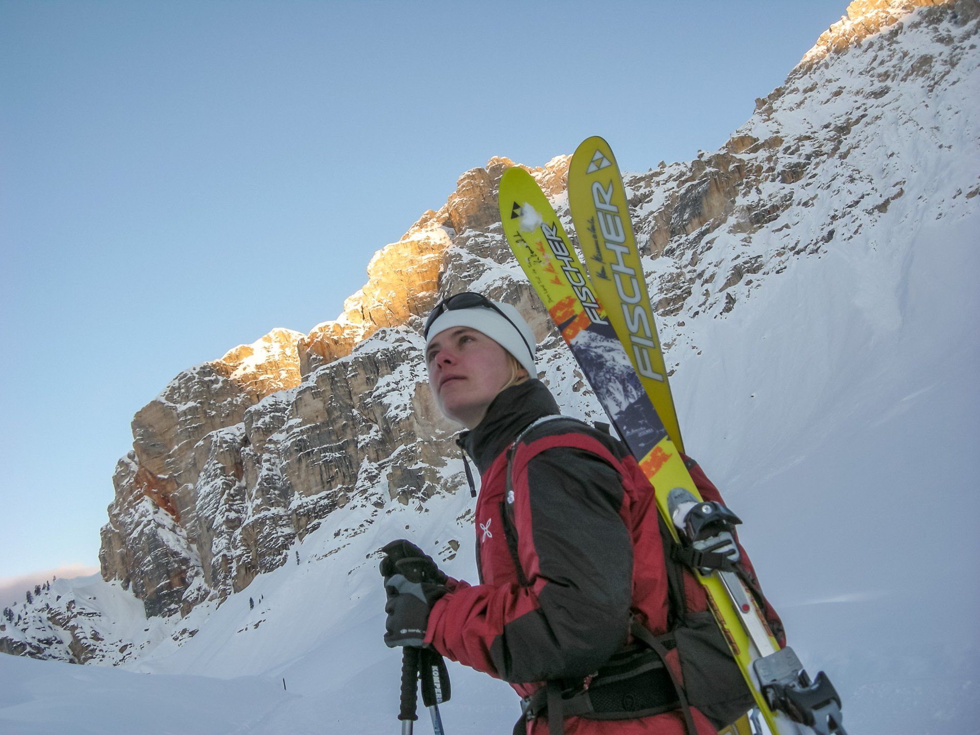 Eine Person, die Skier mit dem Wort Fischer darauf trägt