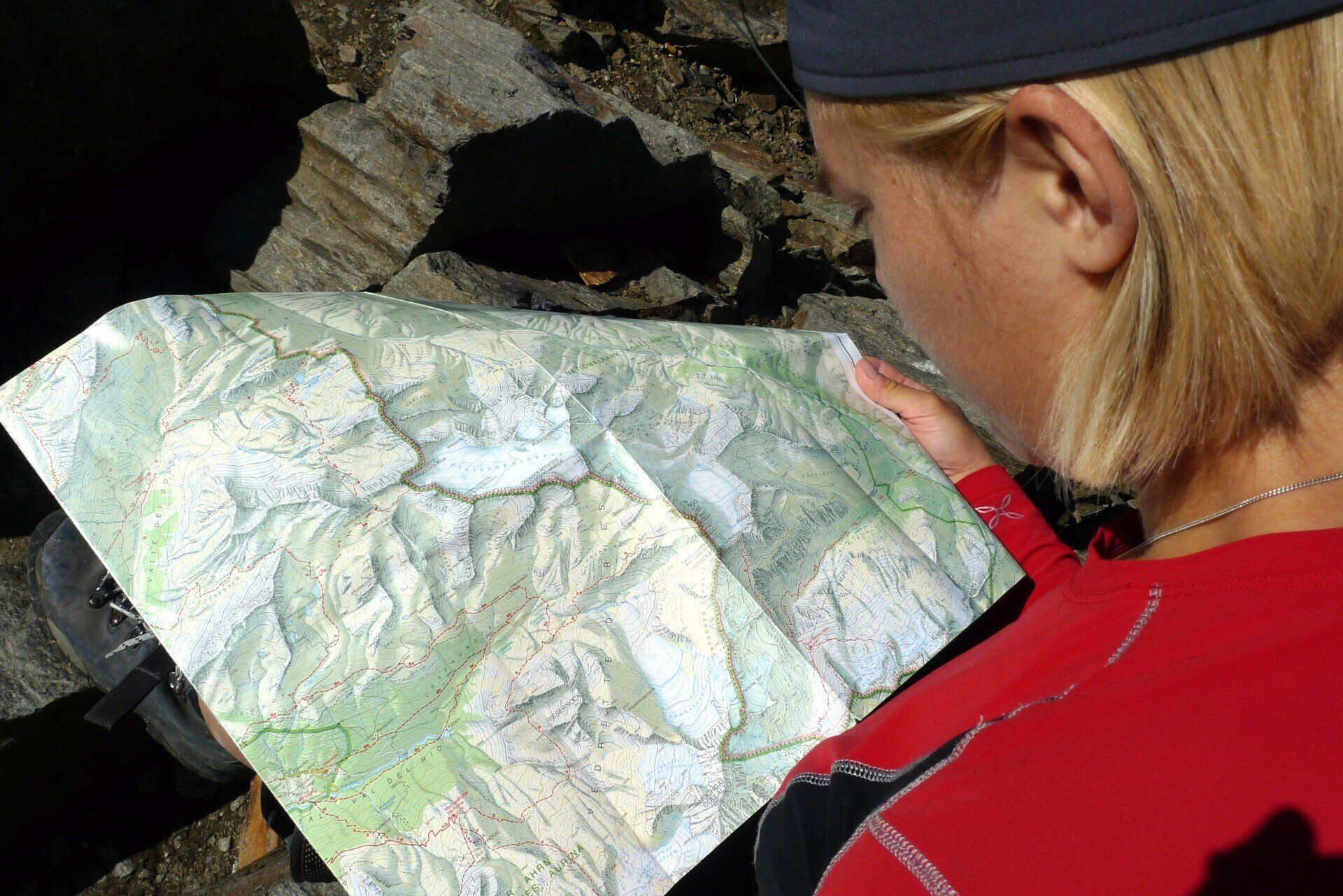 Eine Frau in einem roten Hemd schaut auf eine Karte