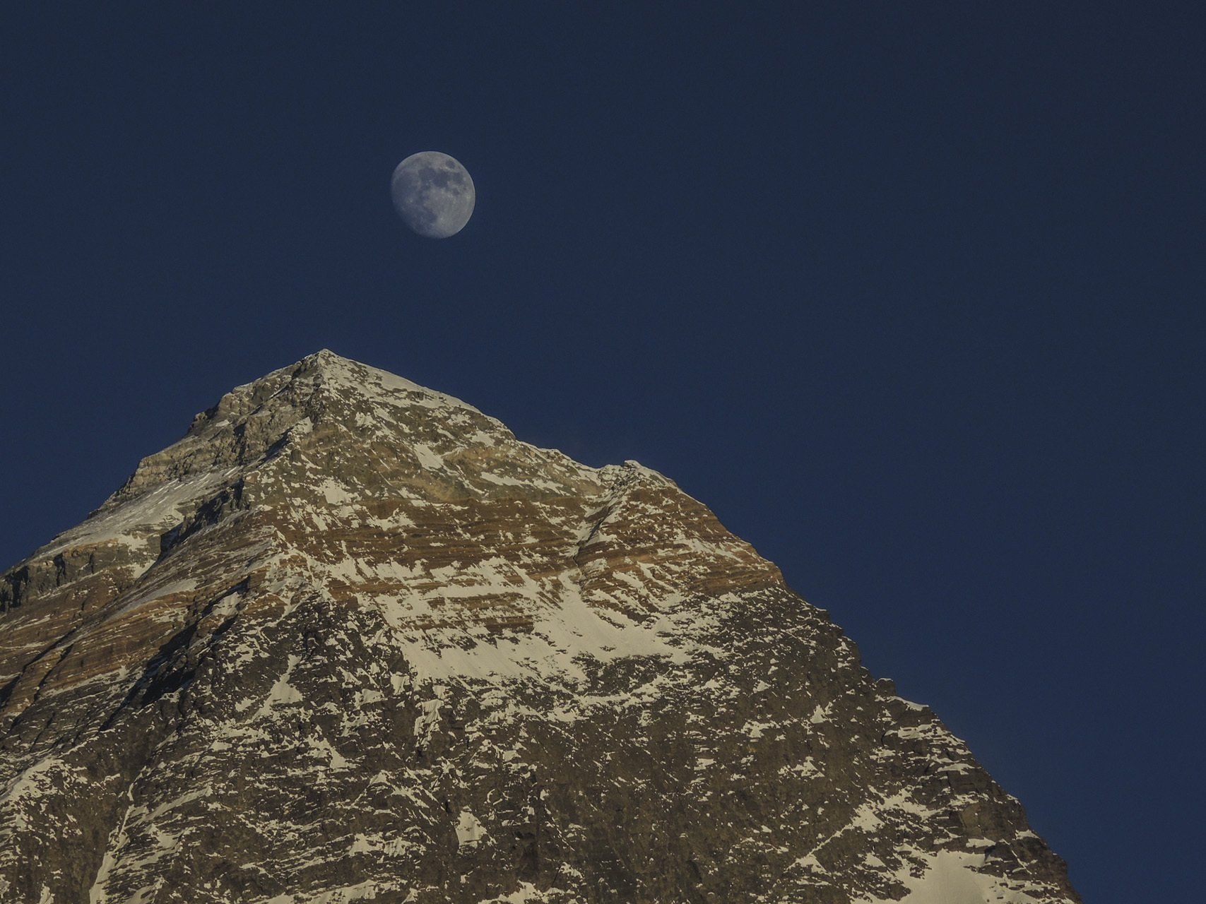 Ein Berg mit einem Vollmond im Hintergrund