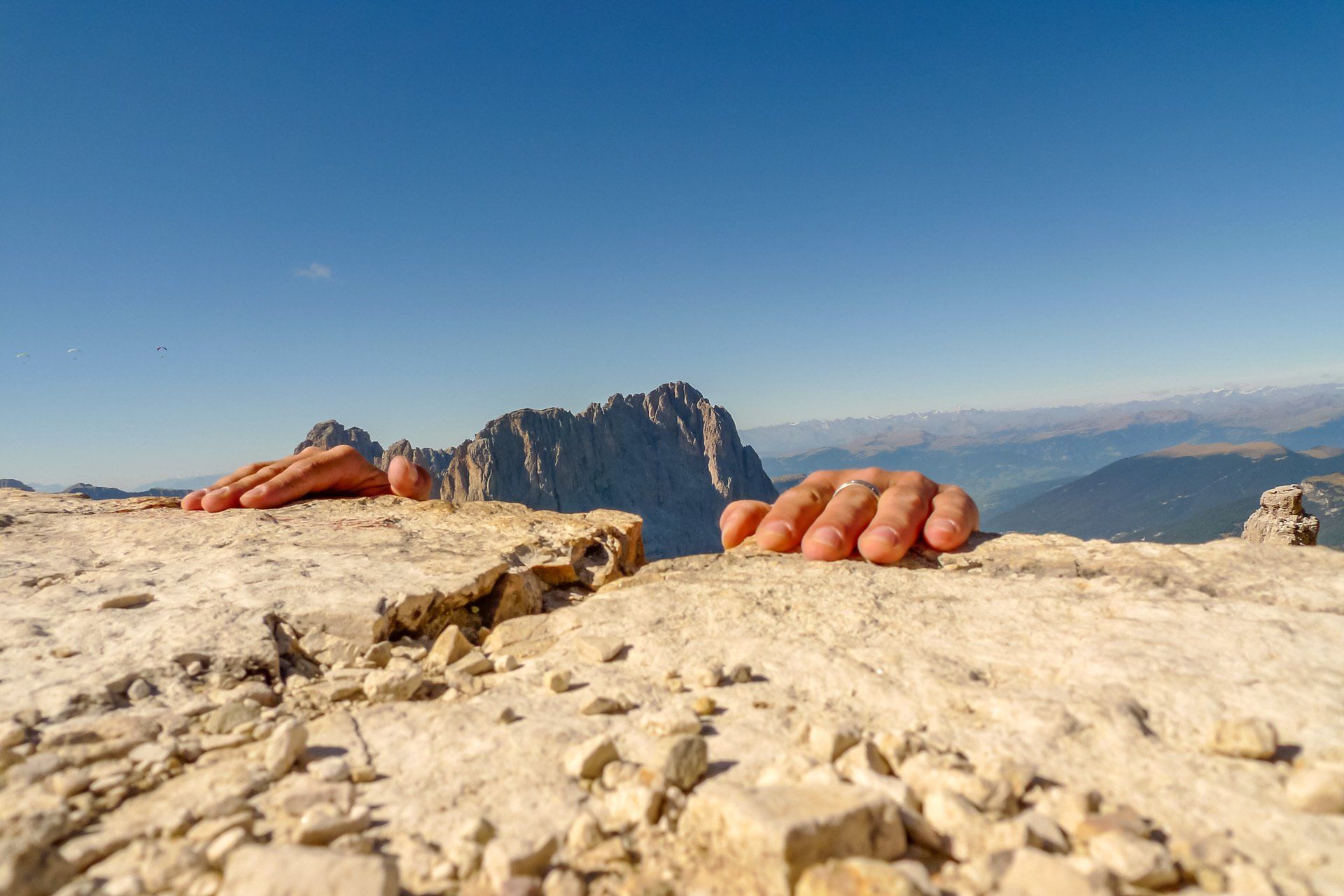 Die Hände einer Person ragen aus einem Loch im Boden.
