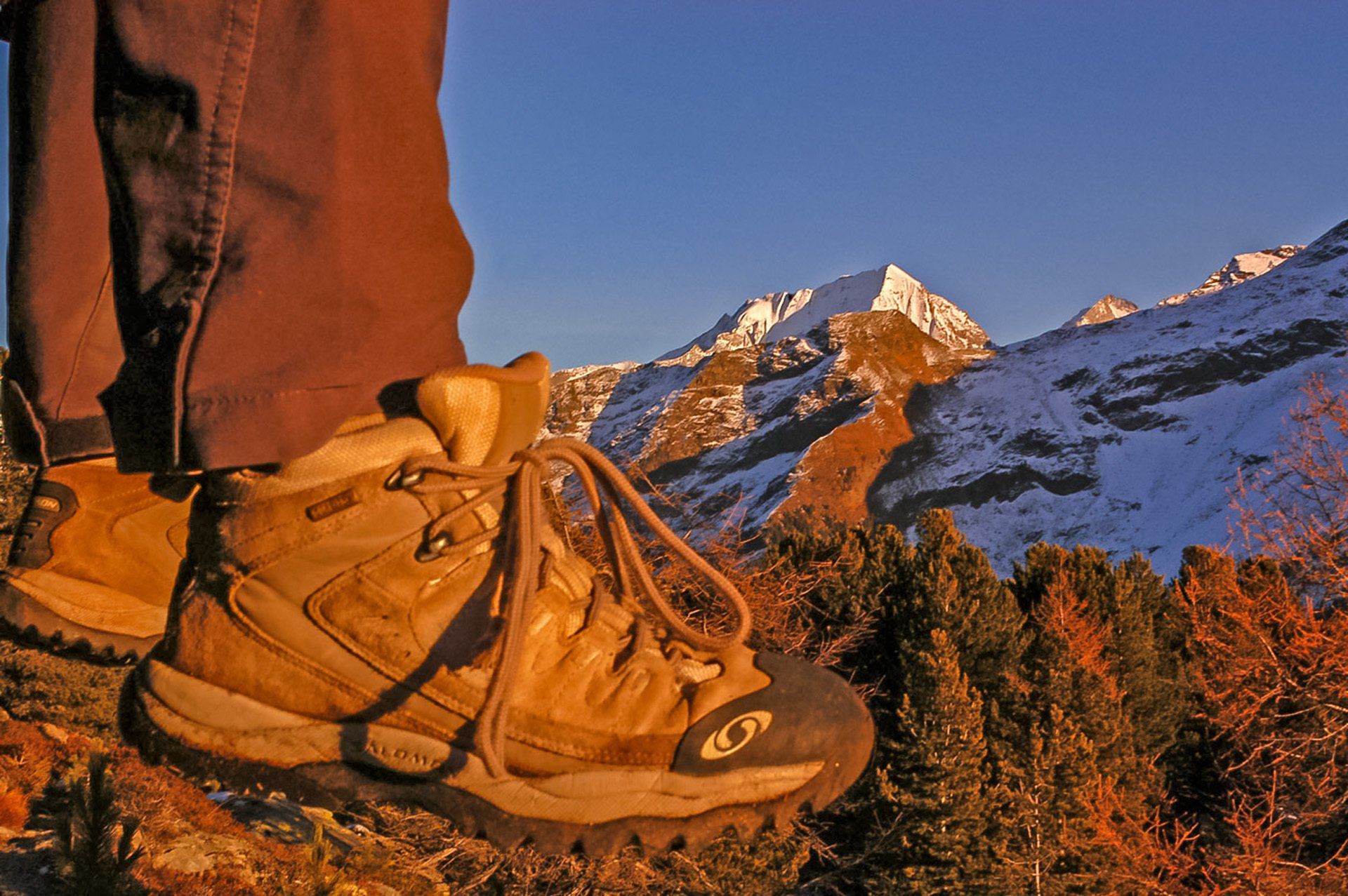 Eine Person, die ein Paar Wanderschuhe trägt, mit einem Berg im Hintergrund