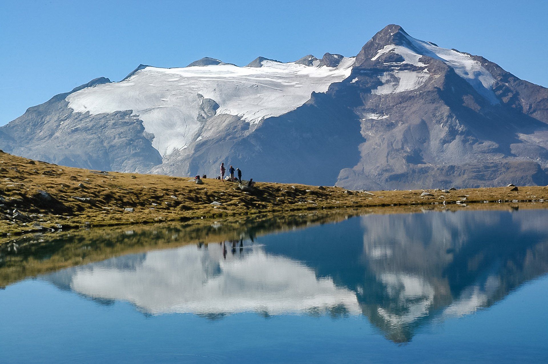 Ein Berg spiegelt sich in einem Gewässer