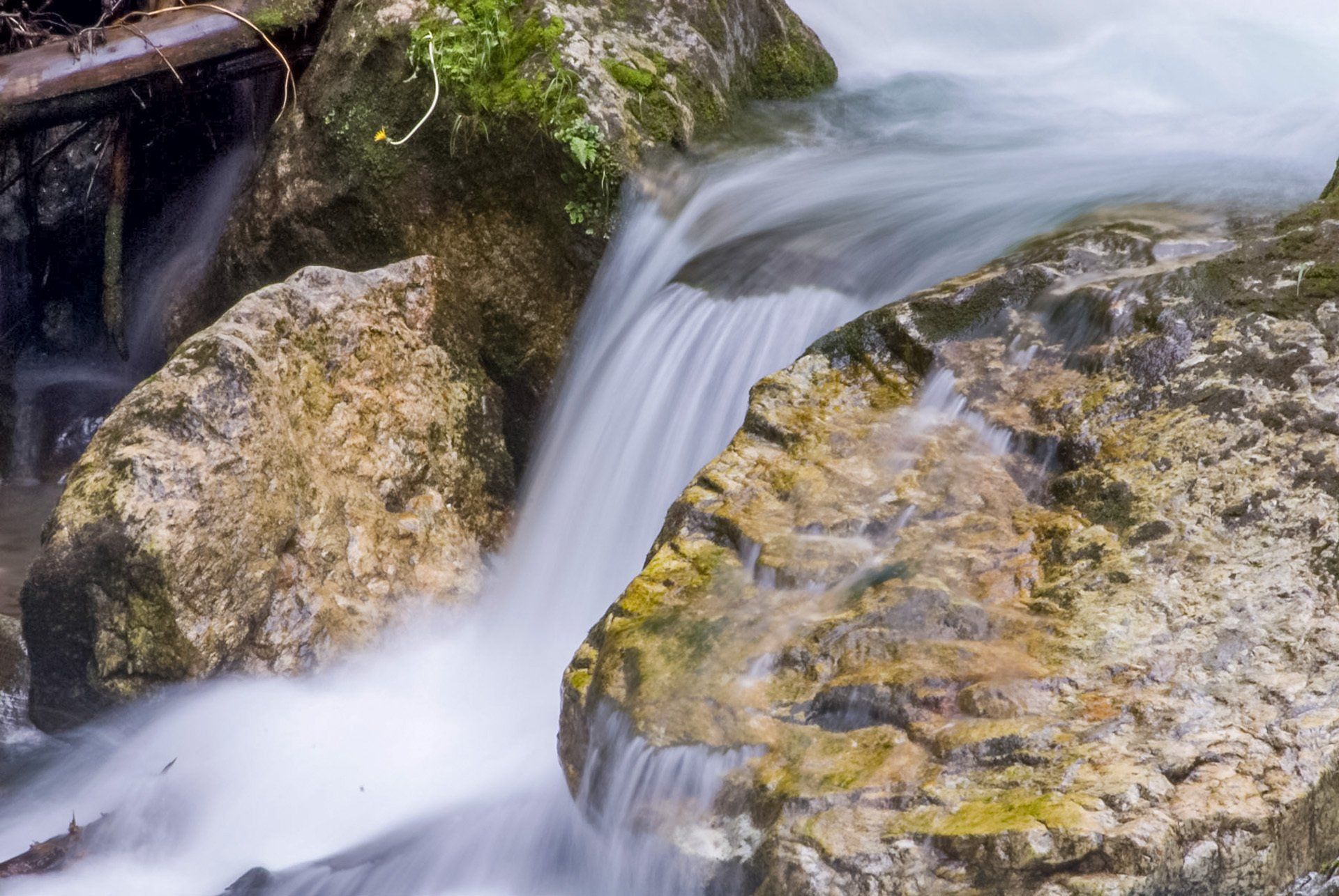 Ein Wasserfall ist von Felsen und Moos umgeben.