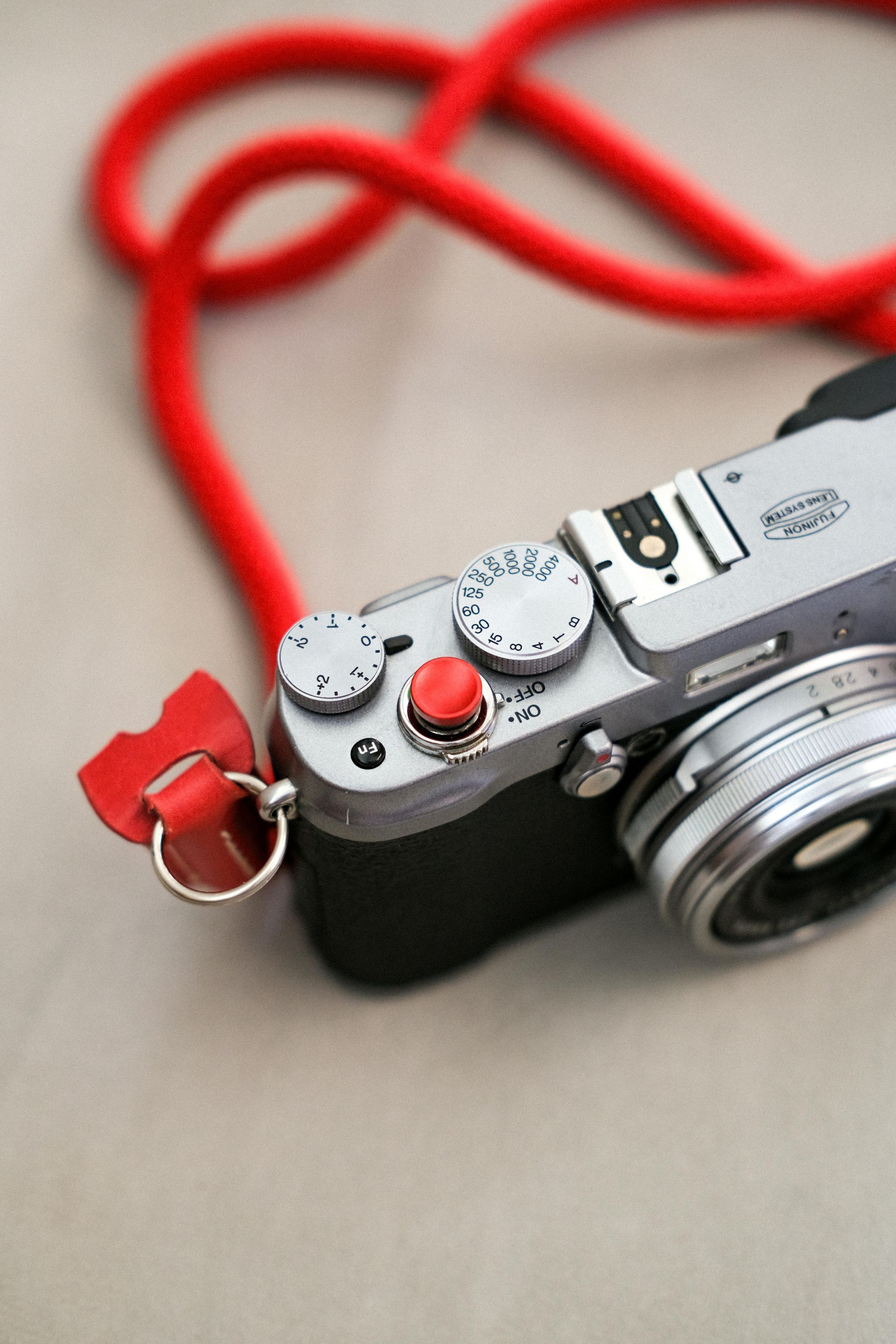 Eine Nahaufnahme einer Kamera mit einem roten Riemen