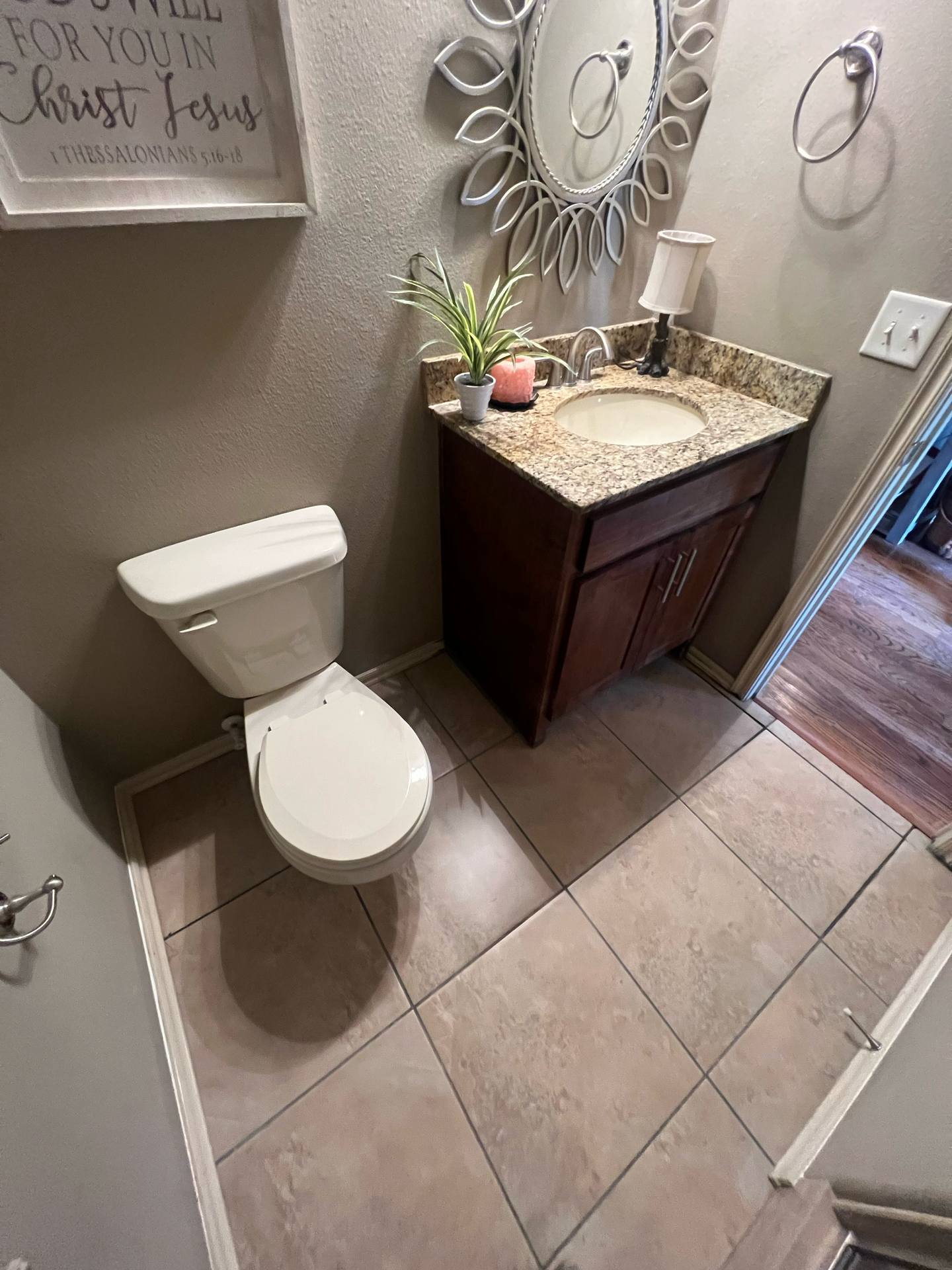 A bathroom with a toilet , sink and mirror.