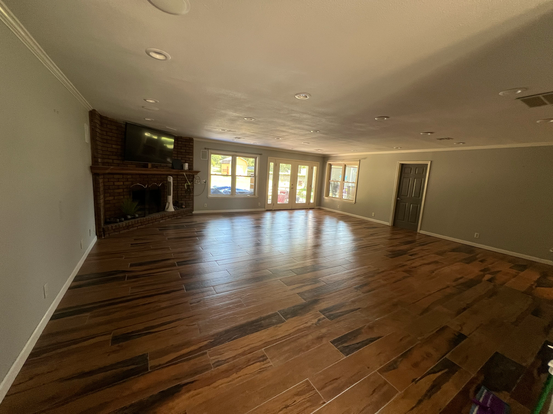 A large empty living room with hardwood floors and a fireplace.