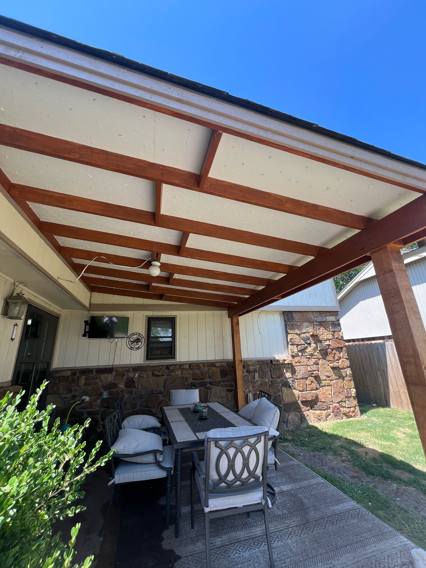 A patio with a table and chairs under a covered patio.