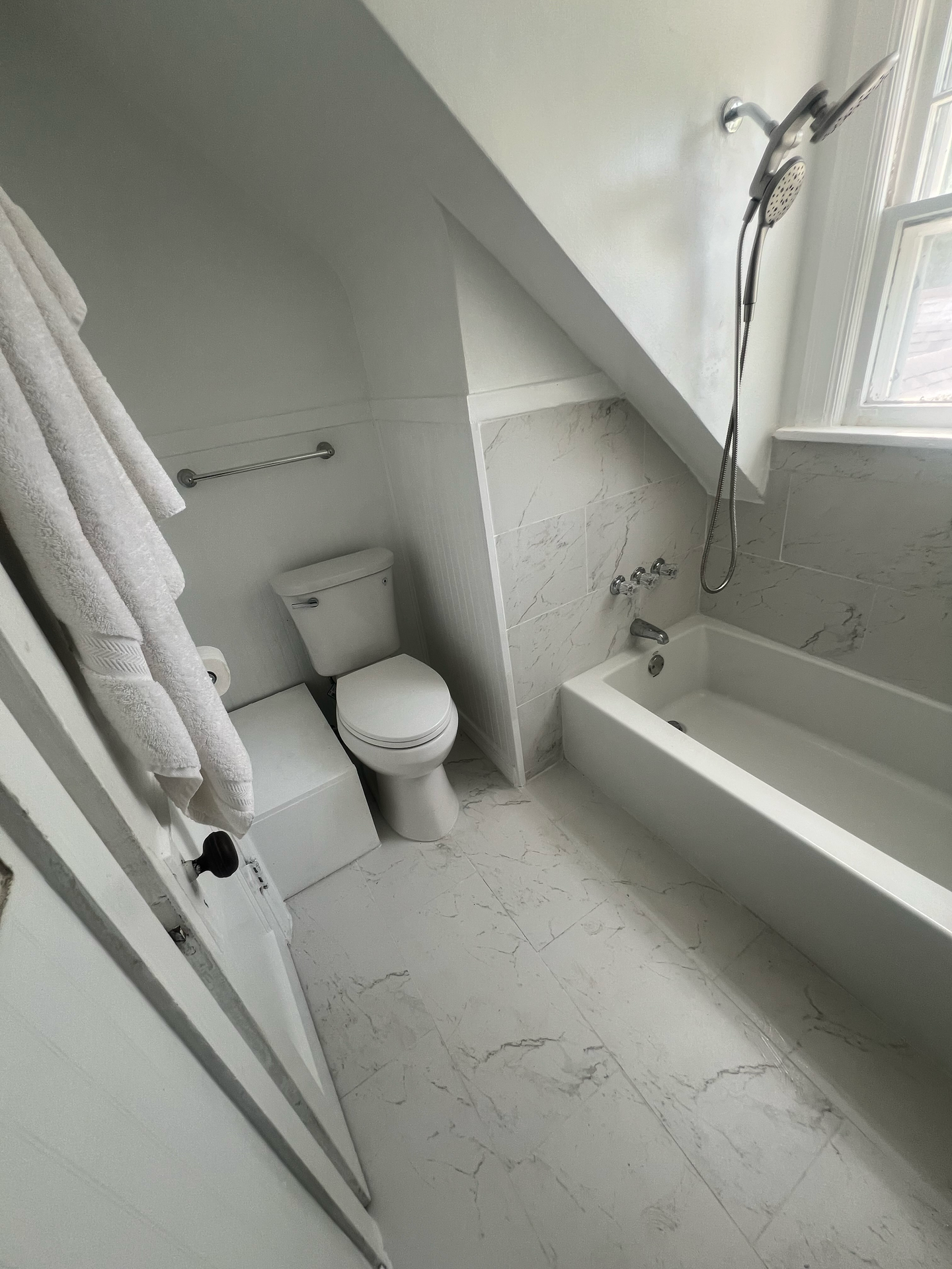 A bathroom with a toilet , bathtub and shower.