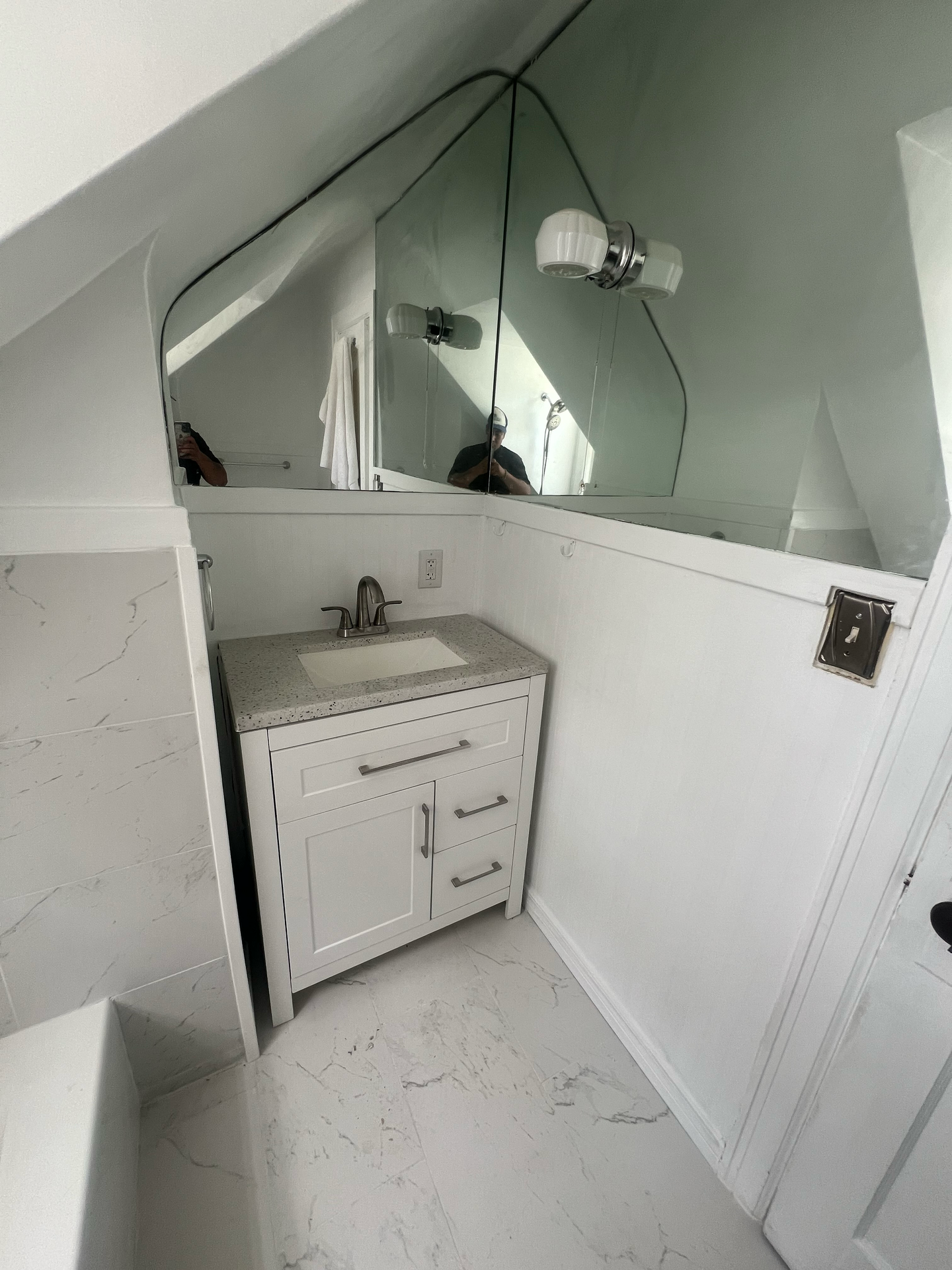 A bathroom with a sink and a large mirror.