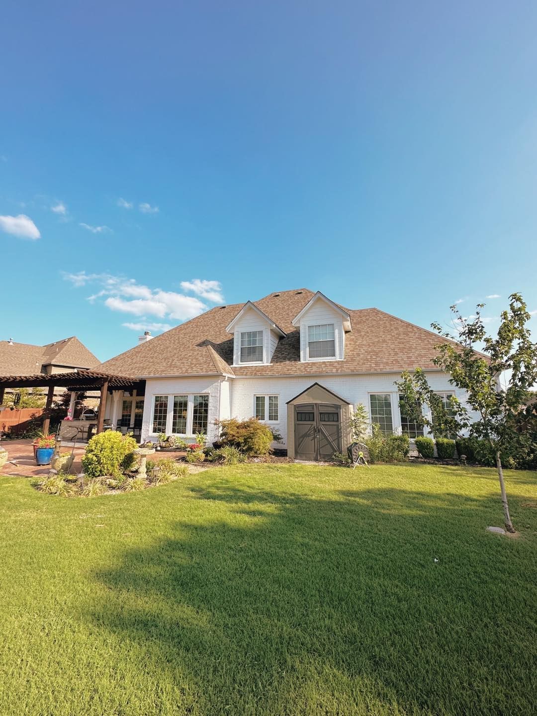 A large white house with a lush green lawn in front of it.