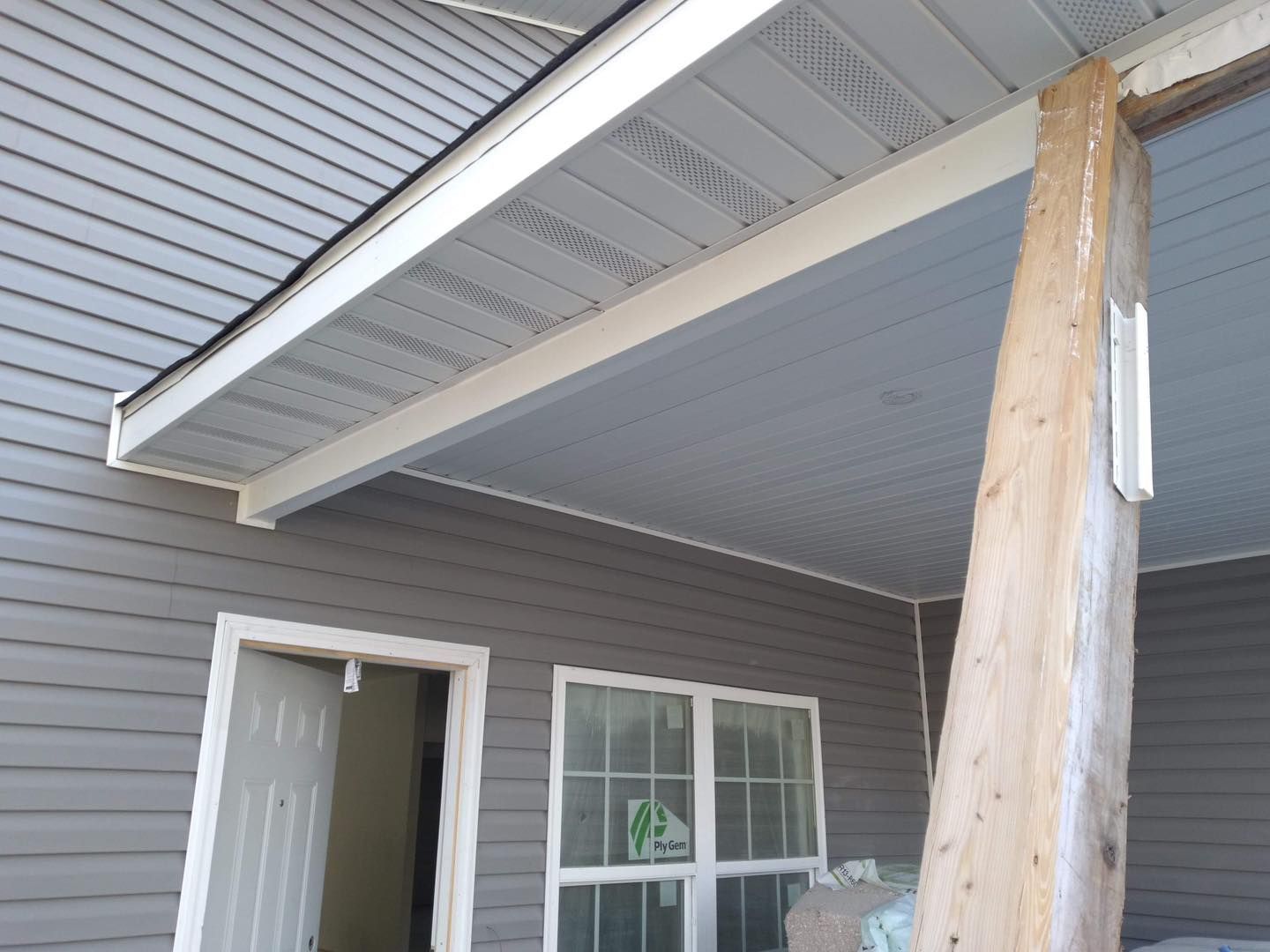 A porch with a white ceiling and a wooden post