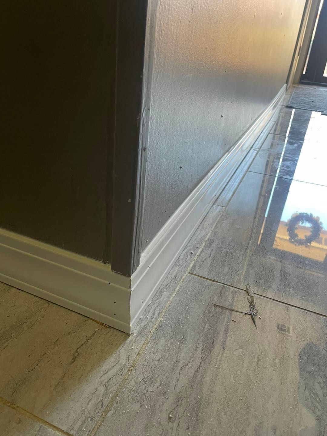 A corner of a room with a door and a tile floor.