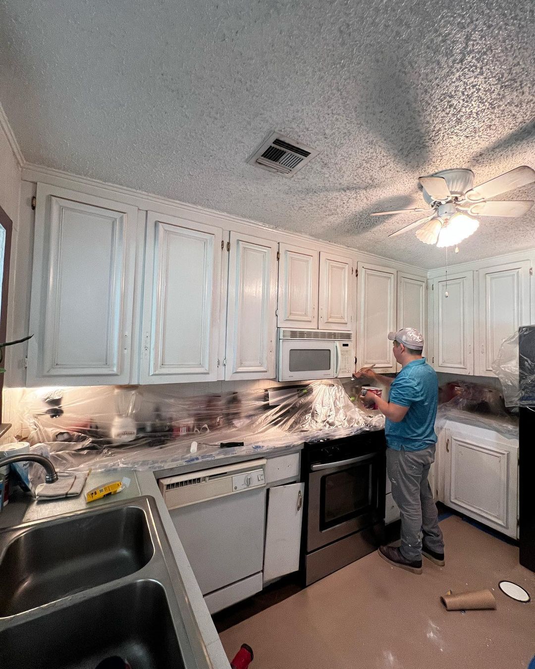 A man in a blue shirt is working in a kitchen.