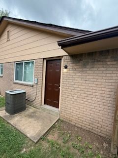 A brick house with a brown door and a window.