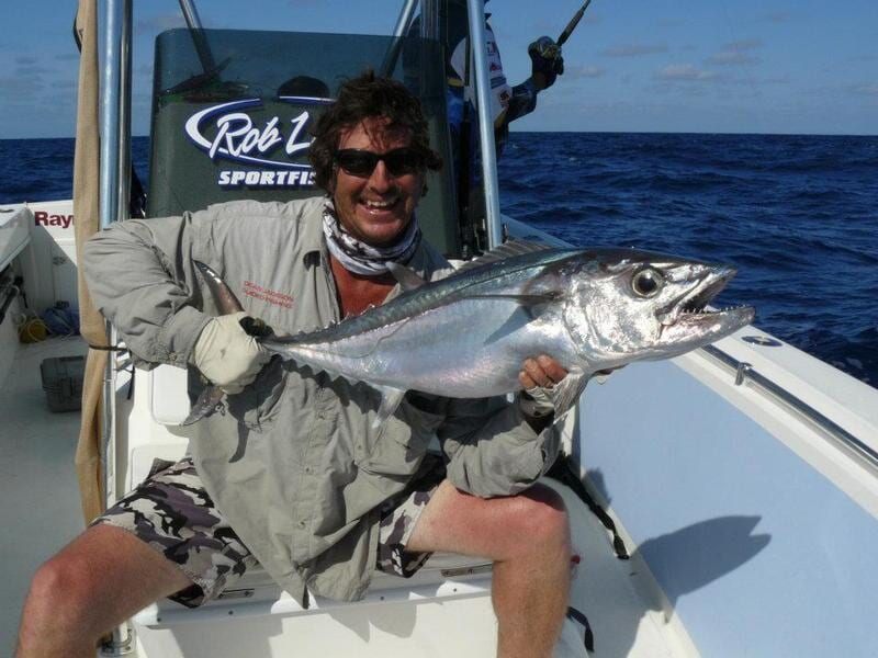 Man carrying bigger fish 3 — Dean Jackson Guided Tours in Winnellie, NT