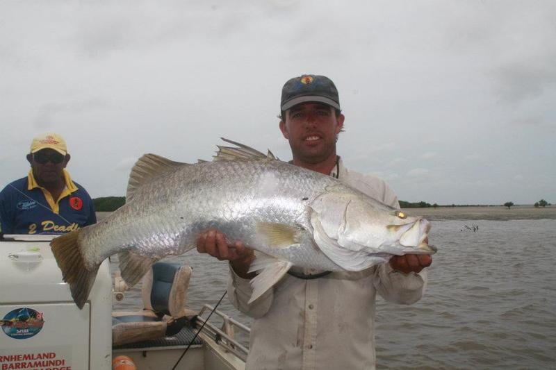 Man carrying bigger fish 4 — Dean Jackson Guided Tours in Winnellie, NT