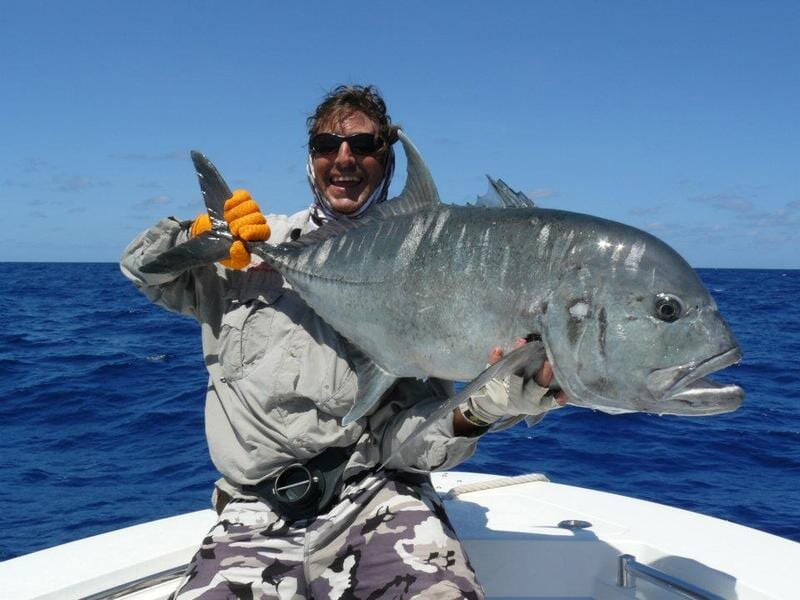 Man carrying bigger fish 6 — Dean Jackson Guided Tours in Winnellie, NT