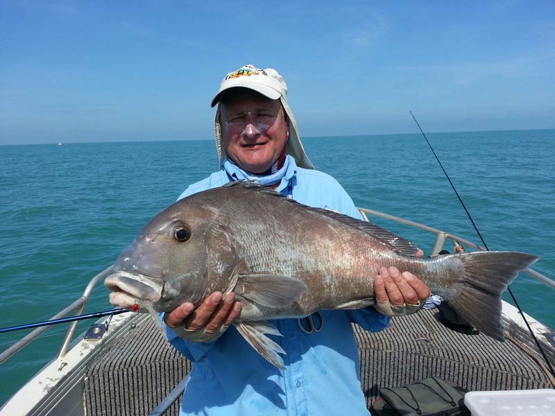 Man carrying bigger fish 9 — Dean Jackson Guided Tours in Winnellie, NT