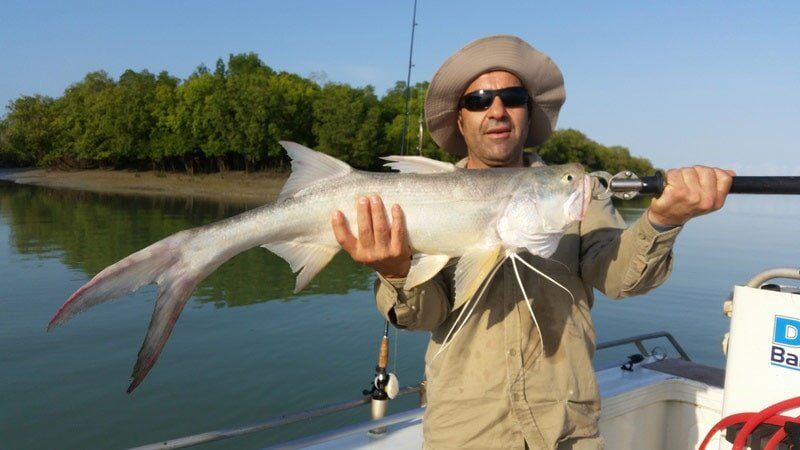 Man carrying bigger fish 11 — Dean Jackson Guided Tours in Winnellie, NT