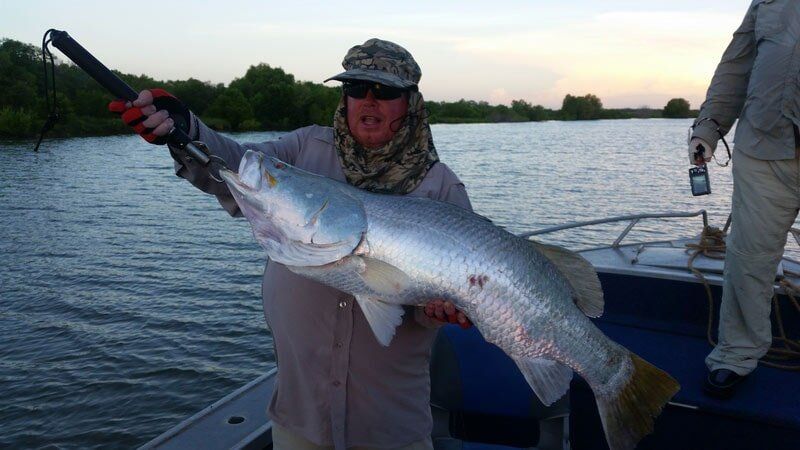 Man carrying bigger fish 12 — Dean Jackson Guided Tours in Winnellie, NT
