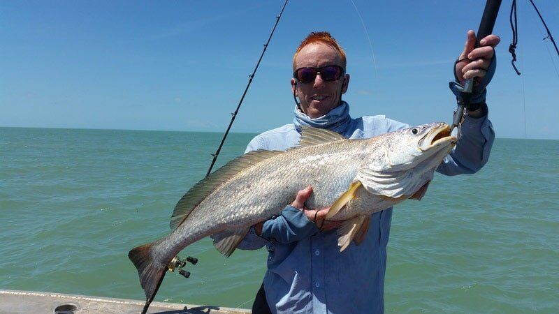 Man carrying bigger fish 13 — Dean Jackson Guided Tours in Winnellie, NT