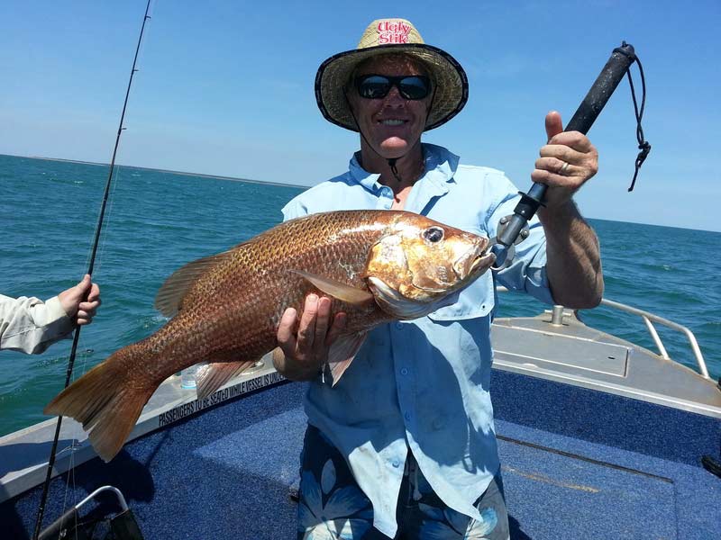 Man carrying fish 3 — Dean Jackson Guided Tours in Winnellie, NT