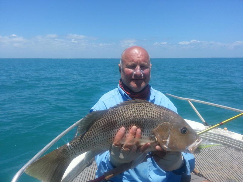 Man carrying fish 5 — Dean Jackson Guided Tours in Winnellie, NT