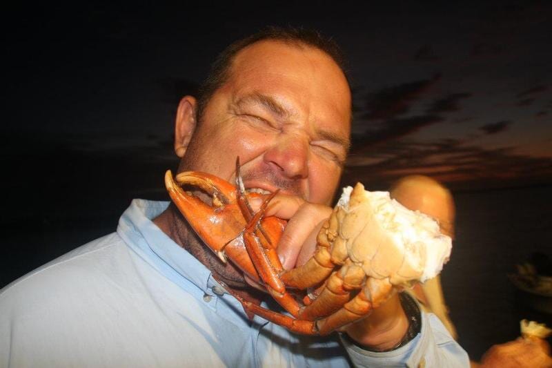 Man eating cooked crab — Dean Jackson Guided Tours in Winnellie, NT