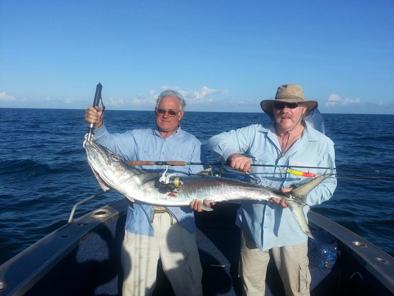 Two men carrying bigger fish 2 — Dean Jackson Guided Tours in Winnellie, NT
