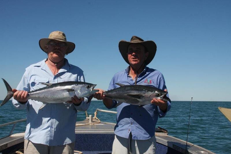 Two men carrying their fish caught — Dean Jackson Guided Tours in Winnellie, NT