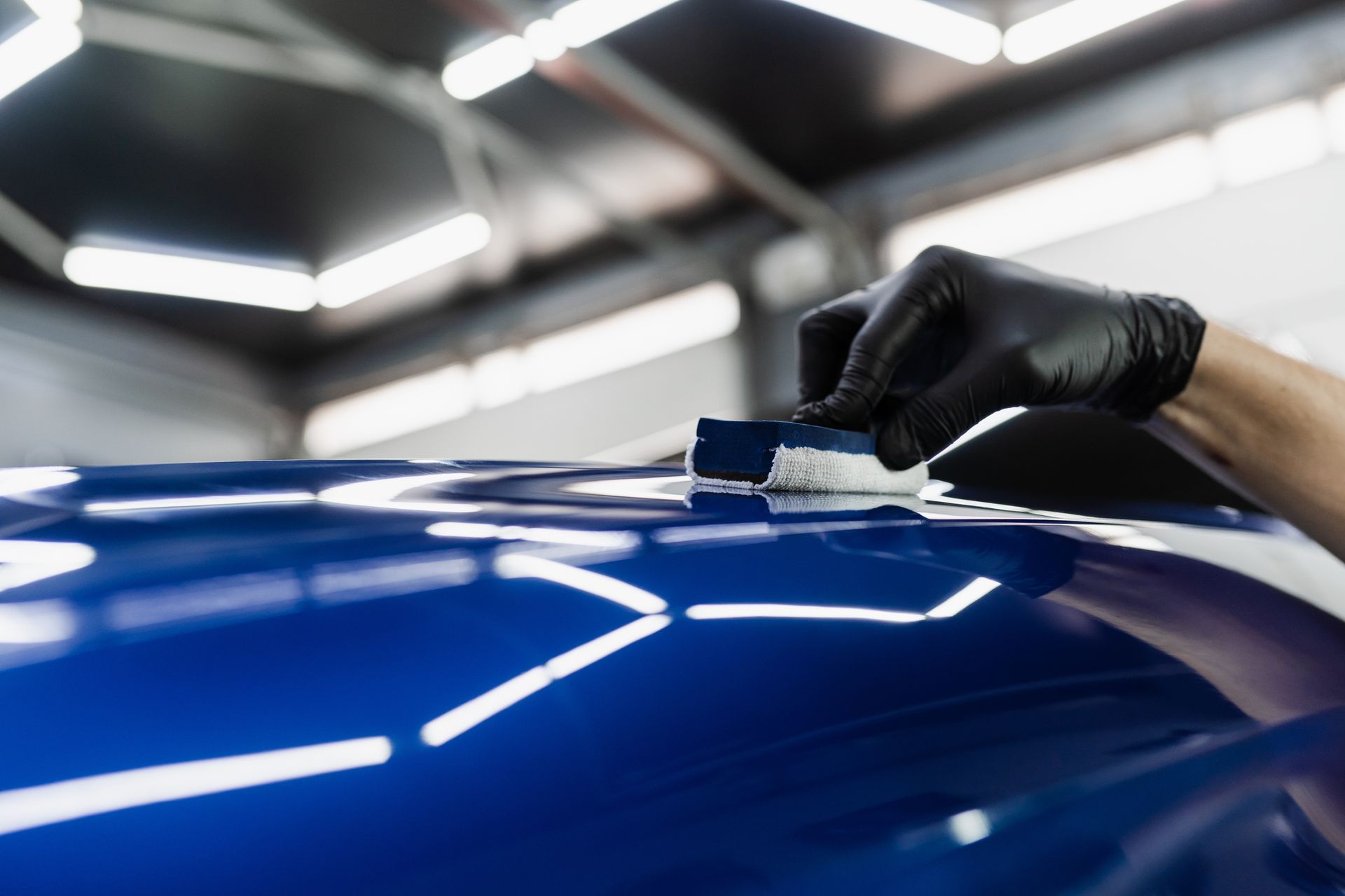 A person is balancing a tire on a wheel in a garage.