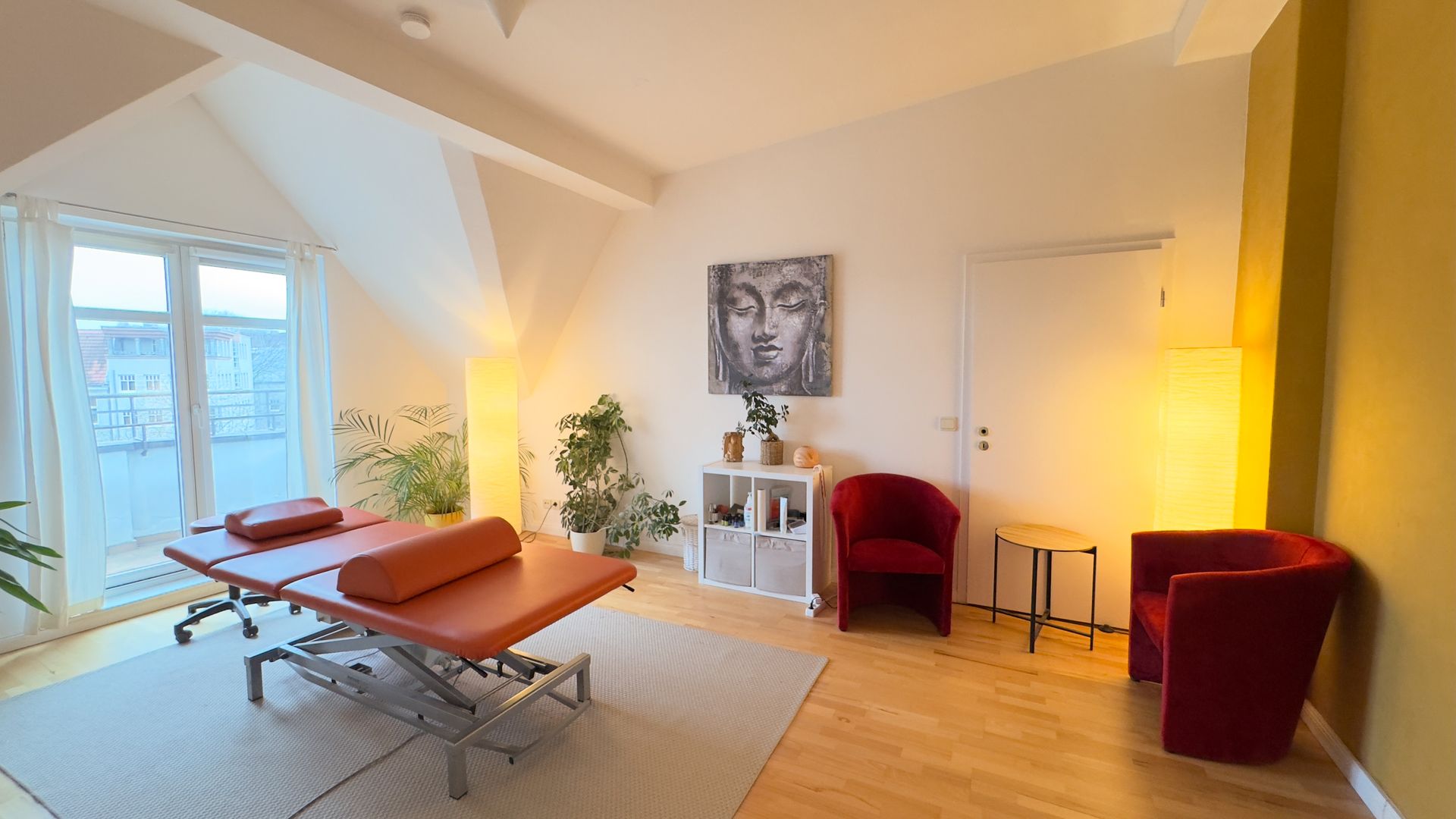 Ein Raum mit einem Massagetisch und zwei Stühlen in der Privatpraxis von Roland Hauf