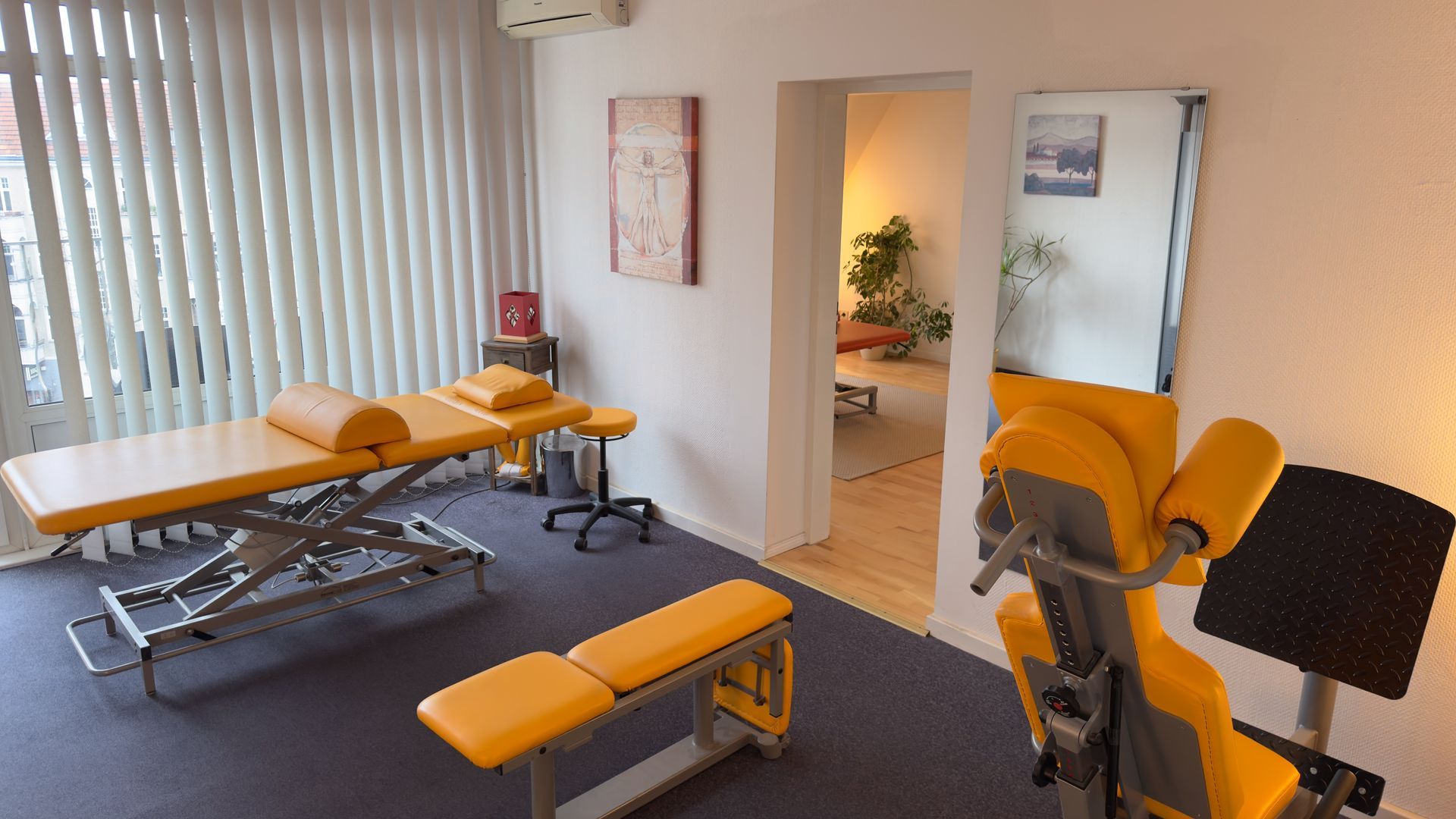 Ein Zimmer mit einer Massageliege und einer Bank darin in der Privatpraxis von Roland Hauf