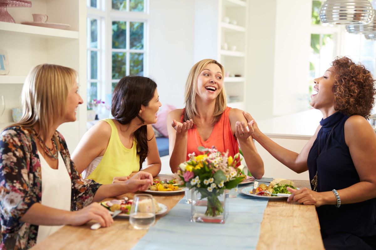 A group of women are sitting at a table eating food.