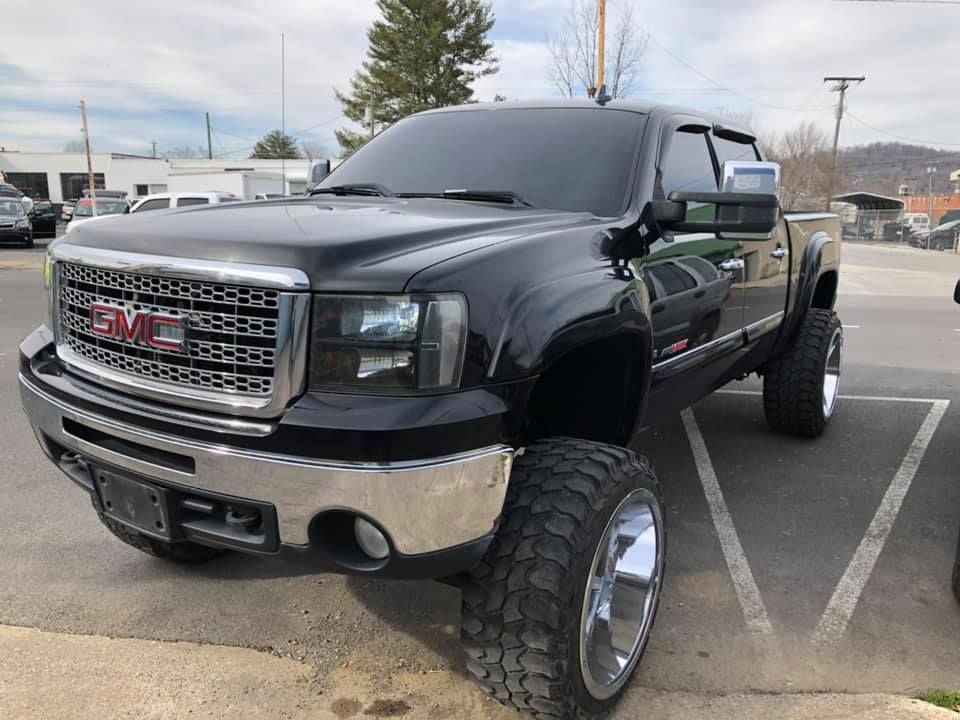 A black gmc truck is parked in a parking lot.