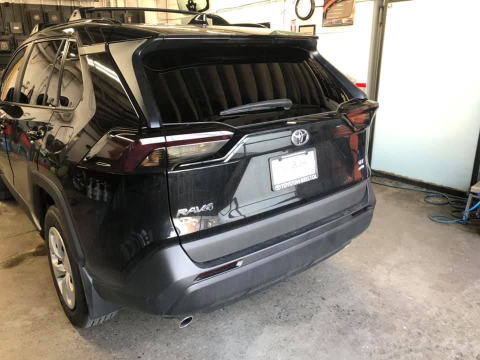 A black toyota rav4 is parked in a garage.
