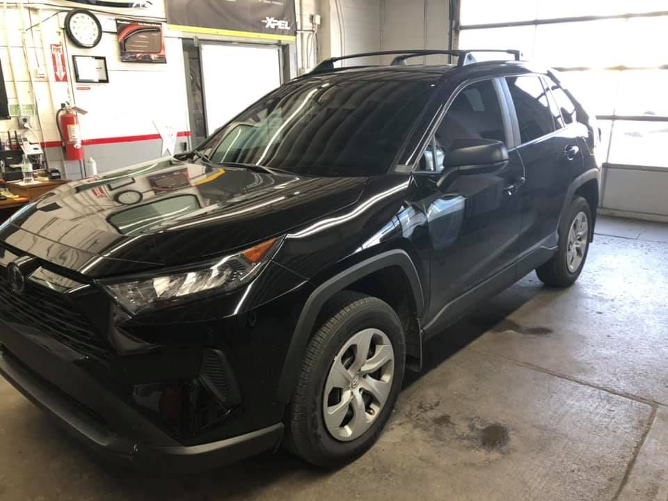 A black toyota rav4 is parked in a garage.