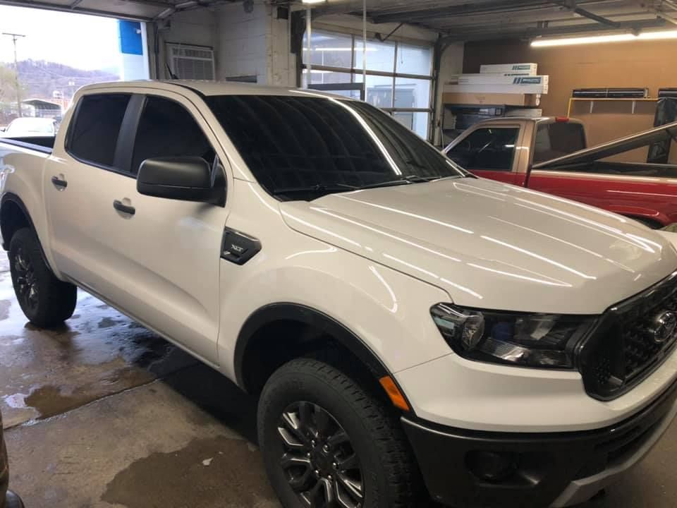 A white pickup truck is parked in a garage.