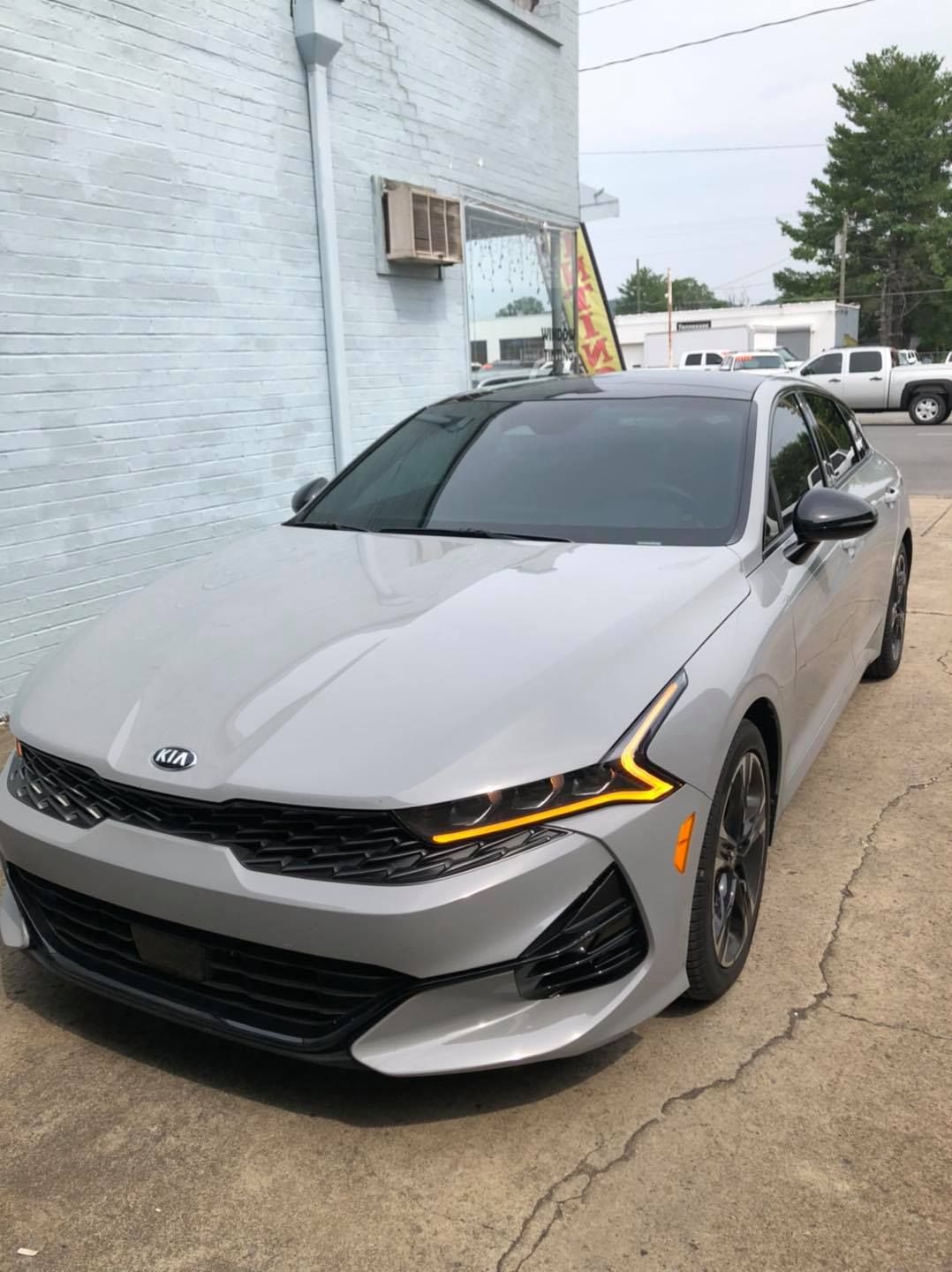 A silver car is parked in front of a building.
