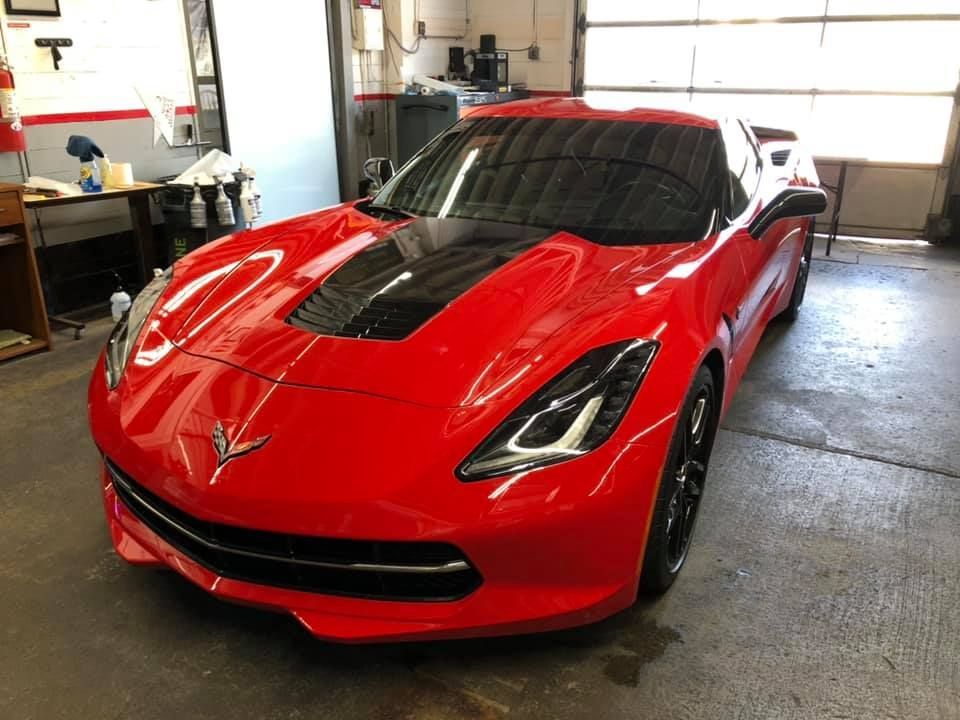 A red sports car is parked in a garage.