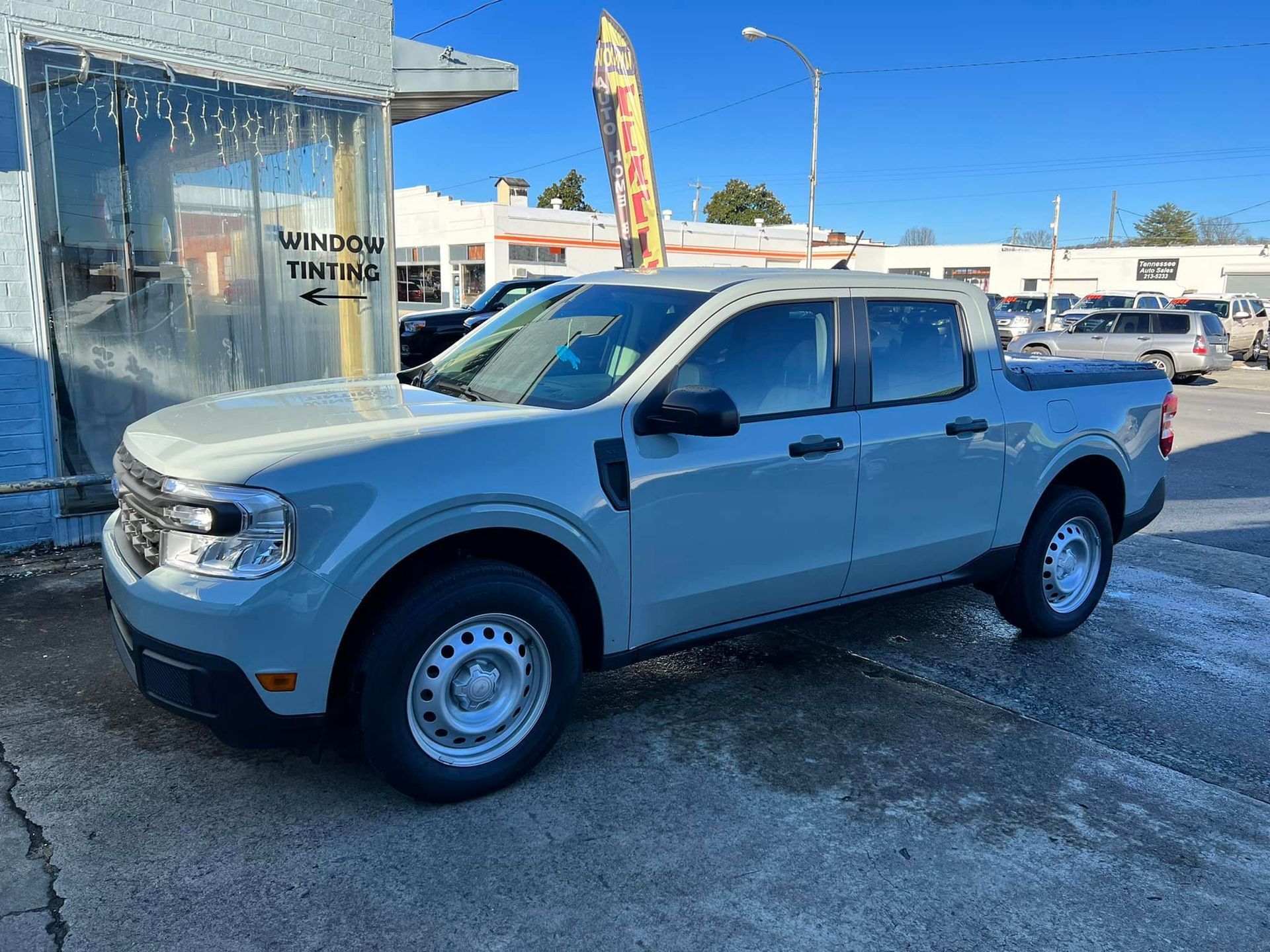 A white pickup truck is parked in front of a building.