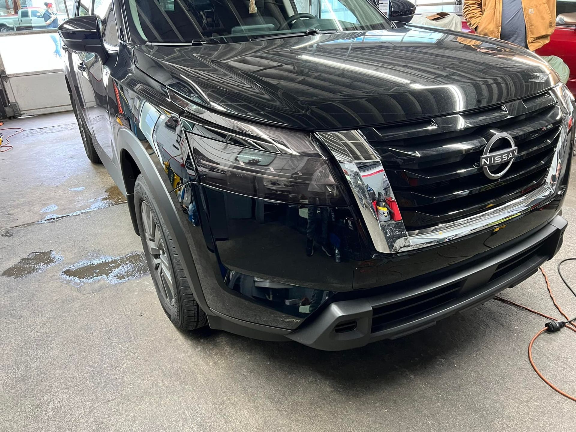 A black nissan pathfinder is parked in a garage.