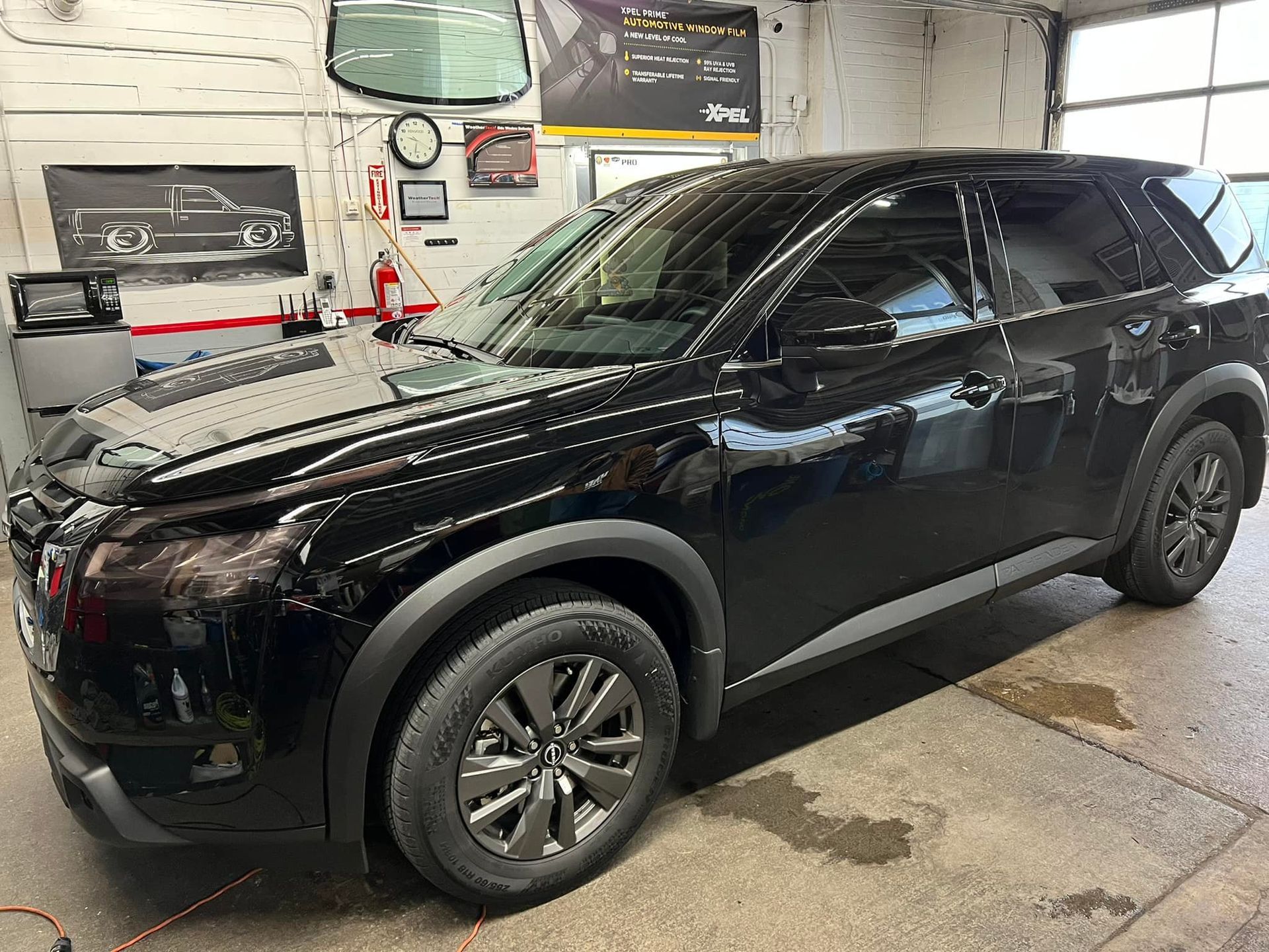 A black suv is parked in a garage.