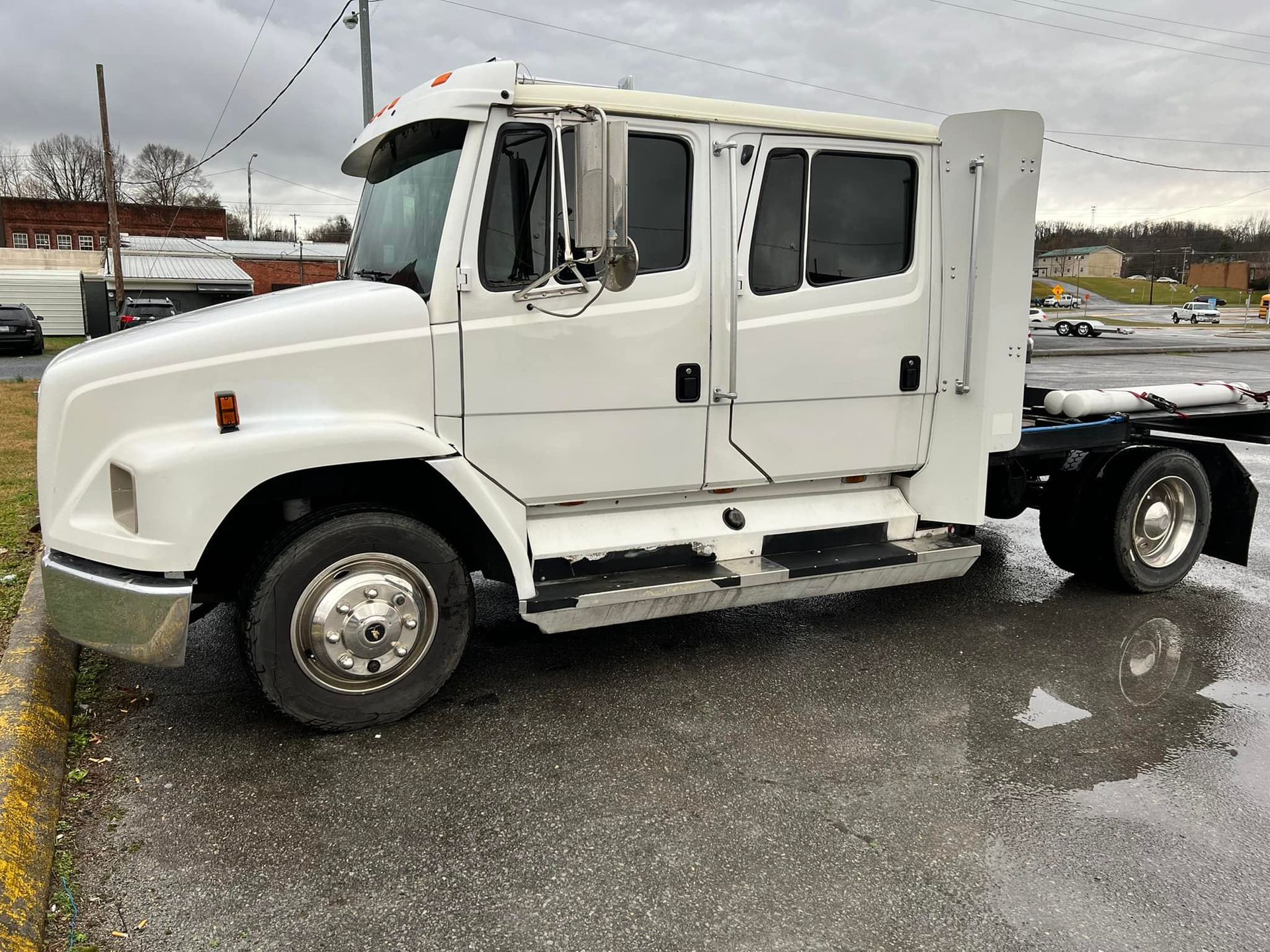 A white semi truck is parked on the side of the road.