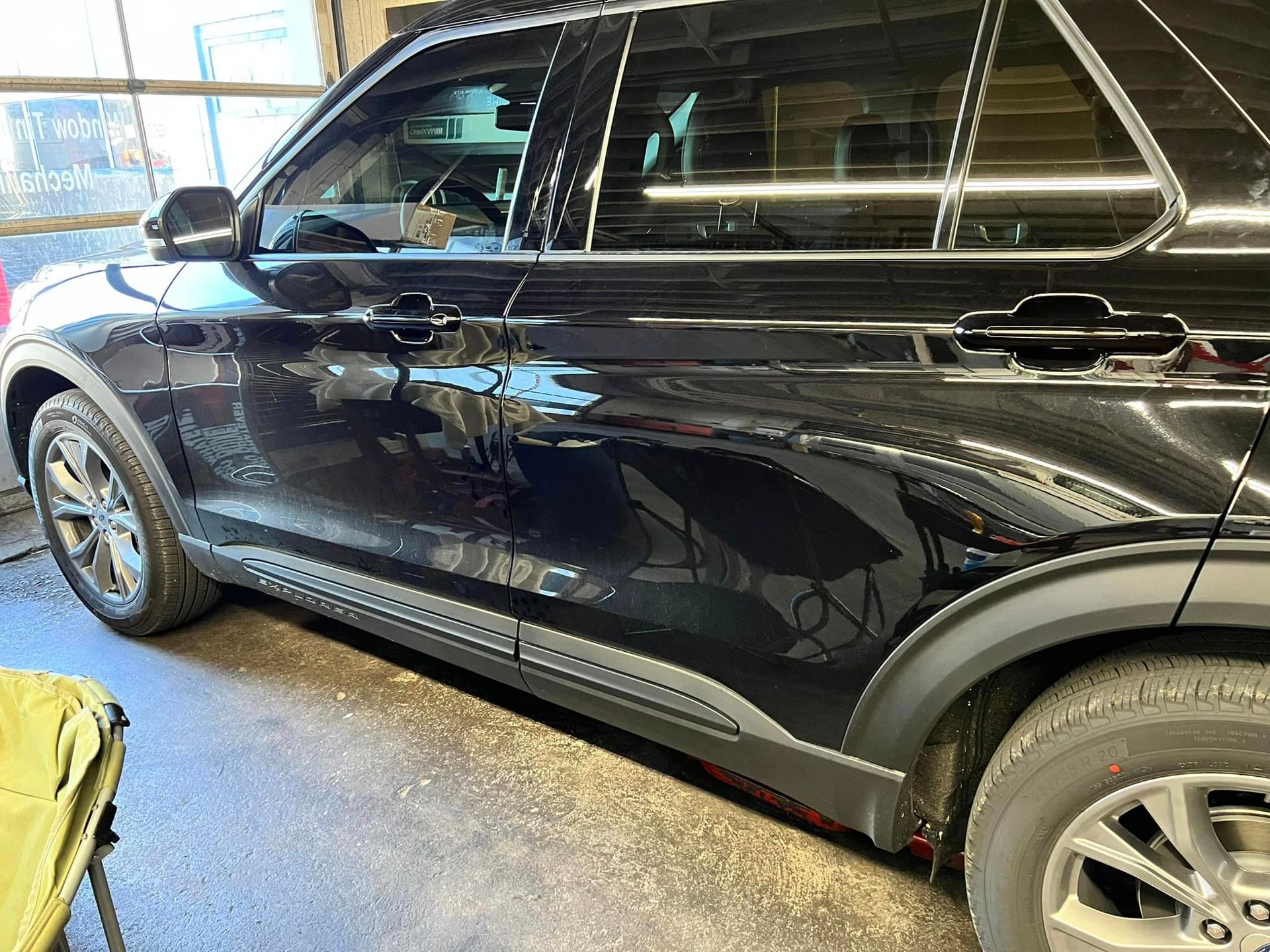 A black suv is parked in a garage.