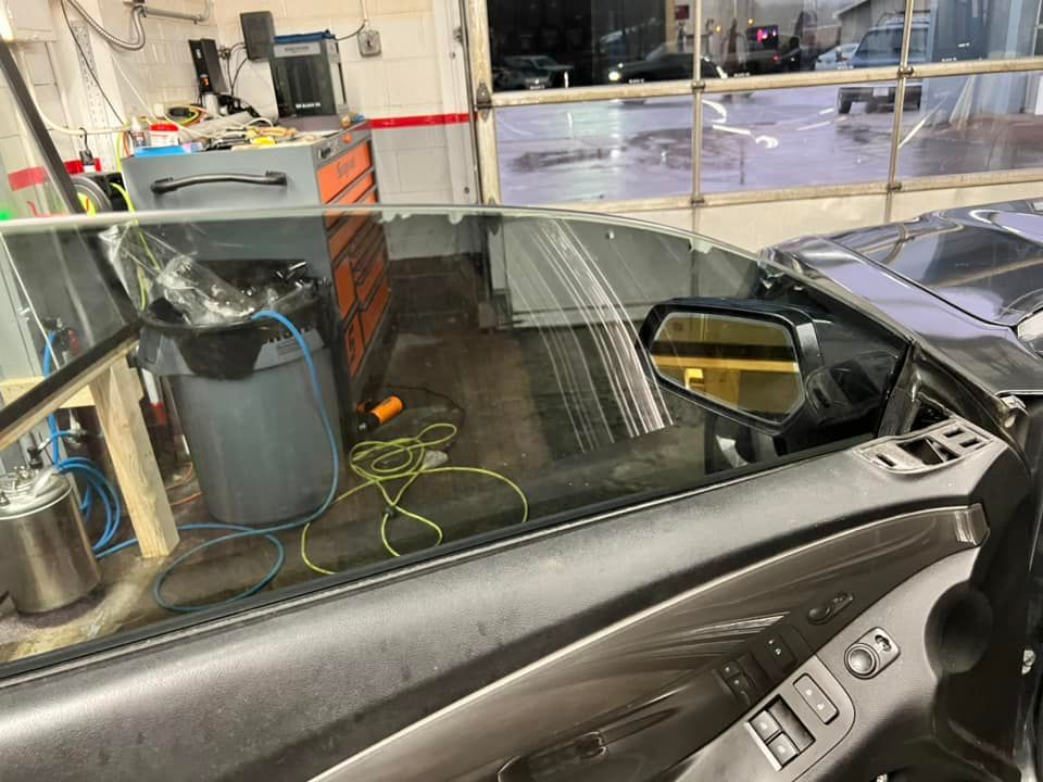 A car is parked in a garage with a broken window.